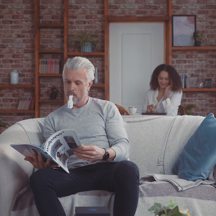 A video of a man reading through a magazine whilst doing alternative sleep ap nea therapy using the eXciteOSA device