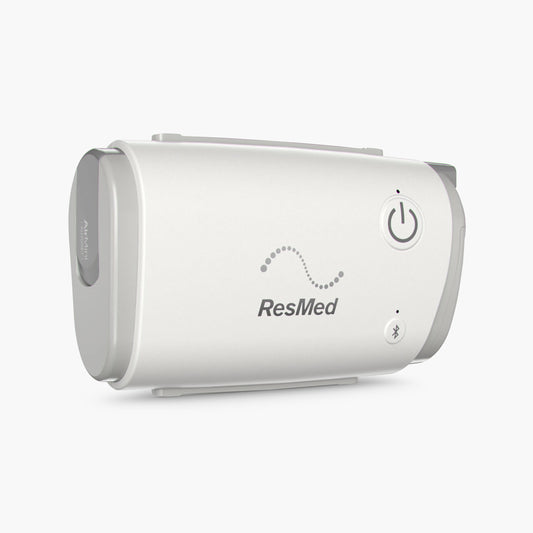 ResMed AirMini™ - AutoSet™ Travel Portable CPAP Machine on grey background.